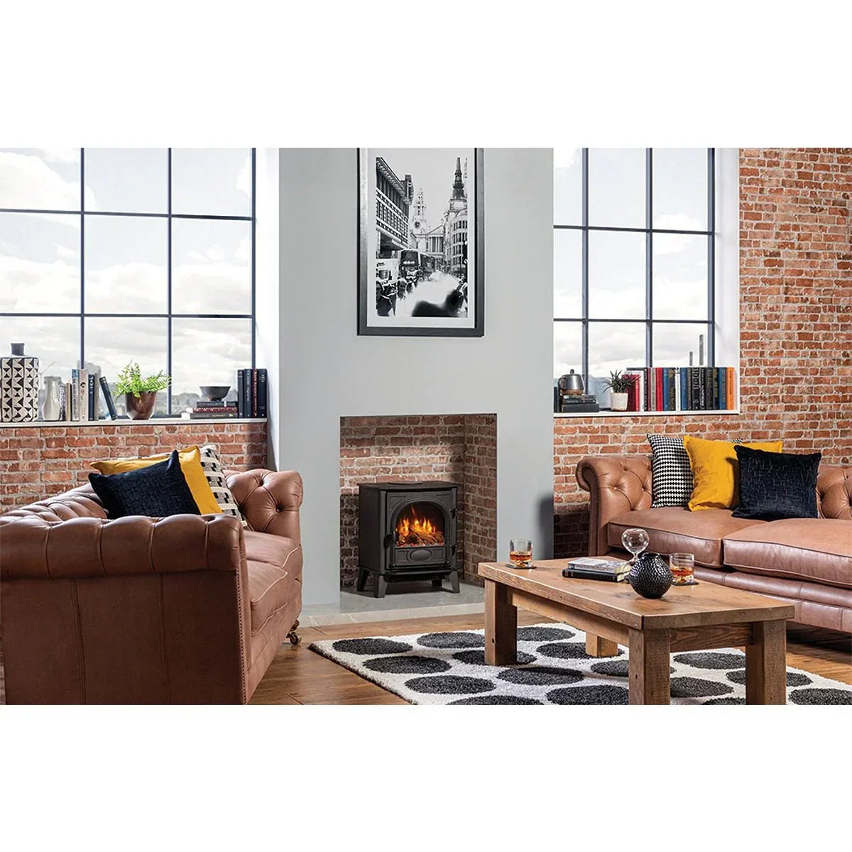 Brown leather sofas with button tufting, wooden coffee table, and stove fireplace in loft lounge