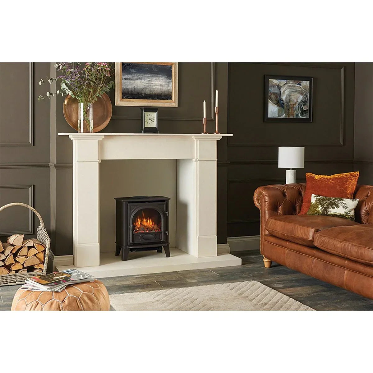 Modern living room with cream fireplace, log burner, brown leather sofa and wood storage basket