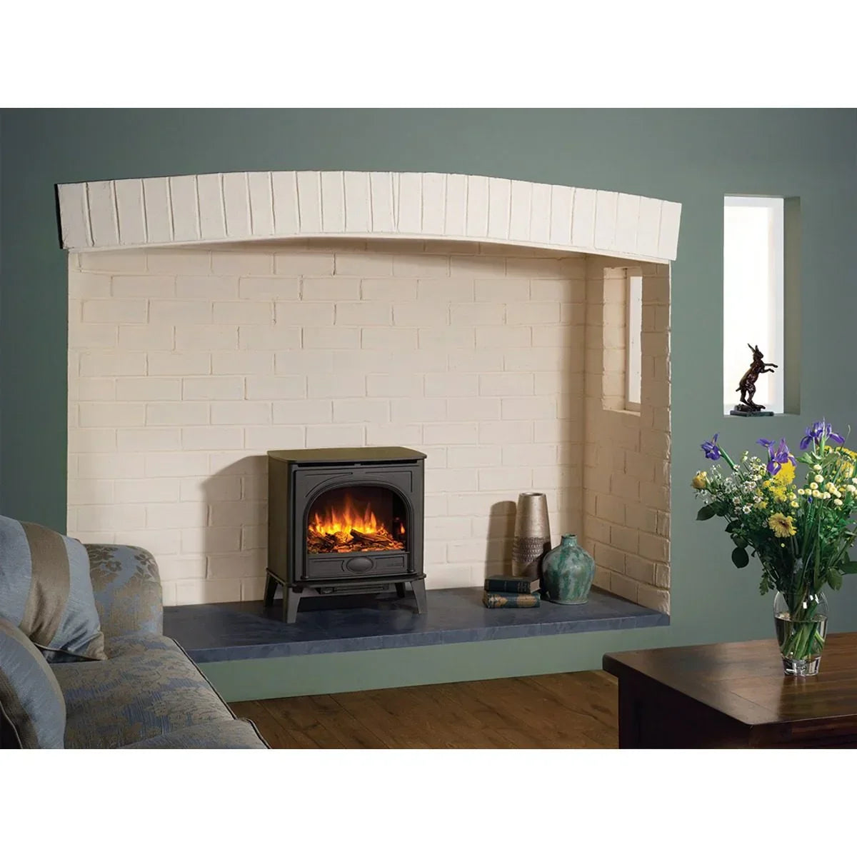 Black electric stove heater on hearth with cream brick surround in living room