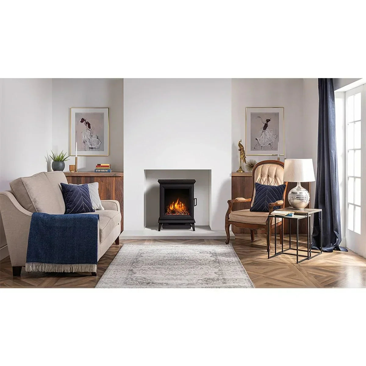 Modern living room with electric fireplace, beige sofa, wood armchair, and decorative accents
