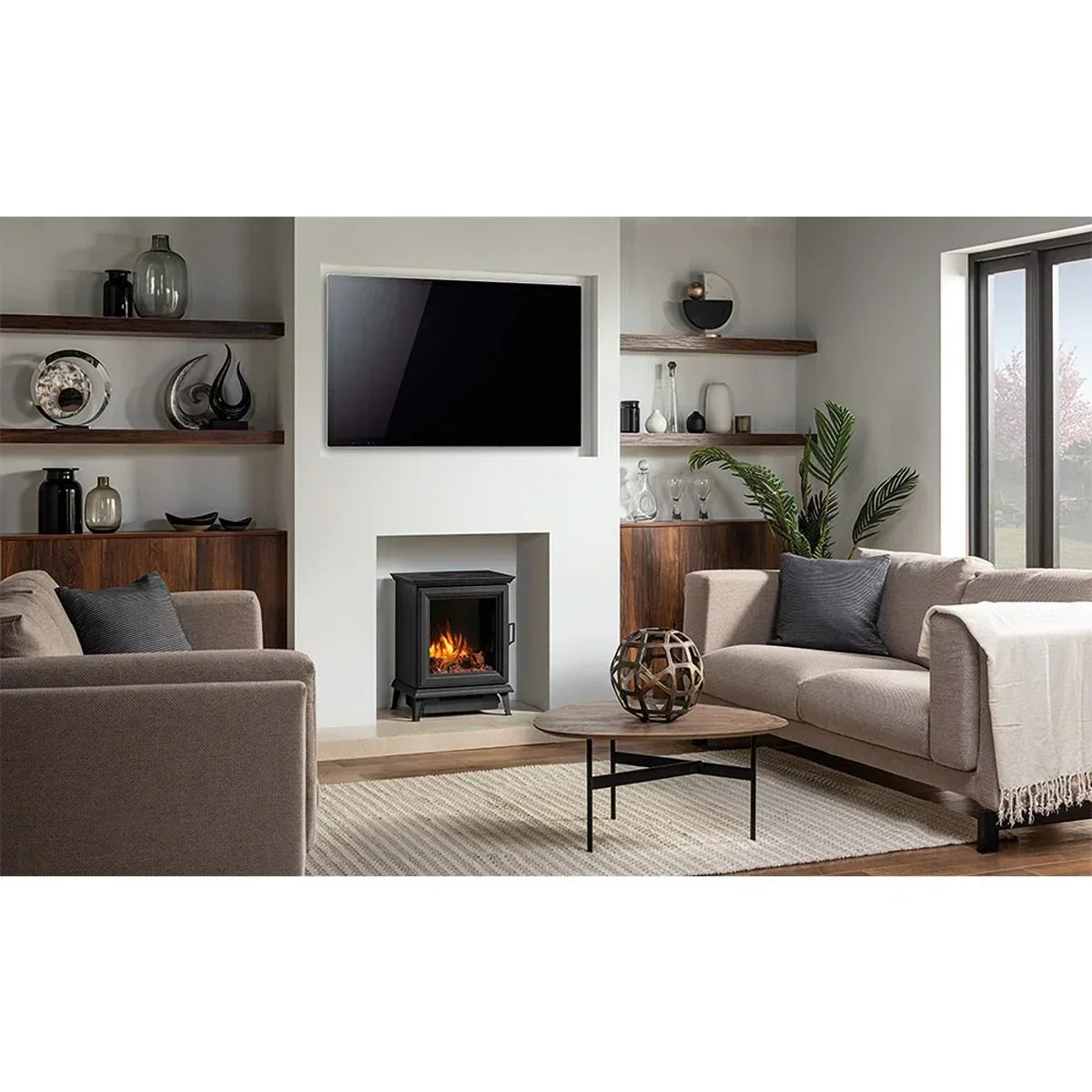 Beige fabric sofas and round wooden coffee table in modern living room with electric fire