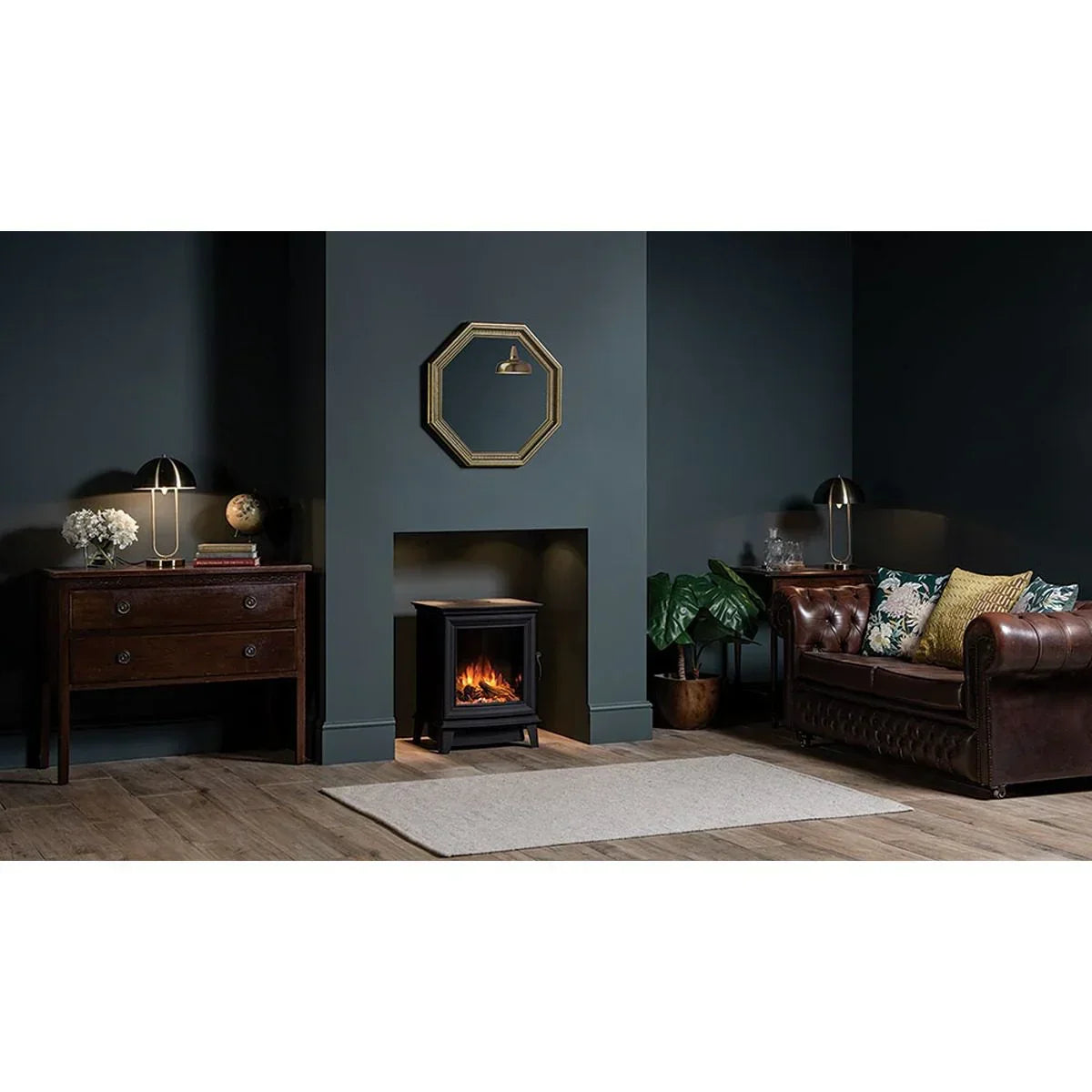 Brown leather sofa and electric fireplace in modern living room with dark walls and wood floor