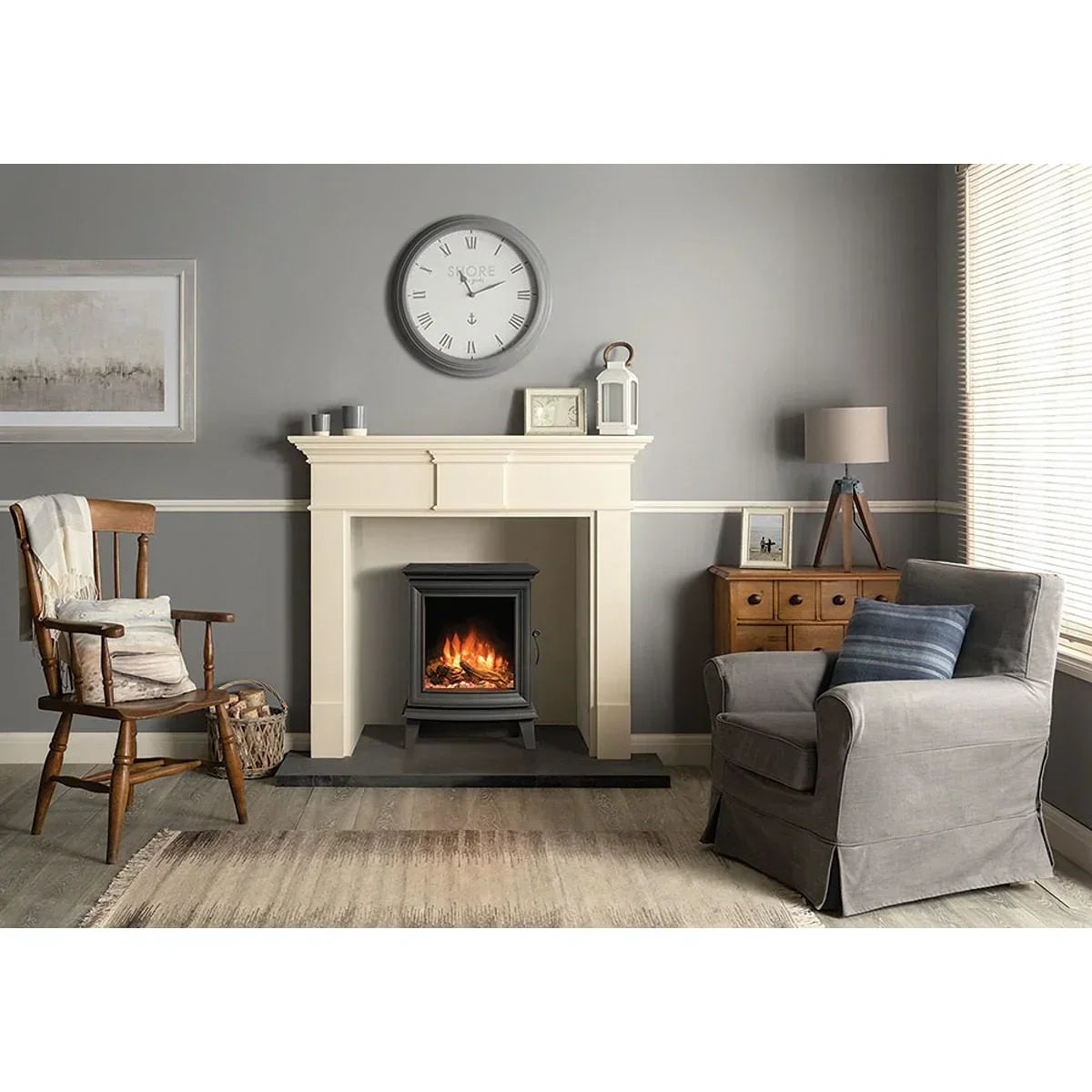 Electric fireplace stove in cream mantel with grey armchair and wooden accent chair
