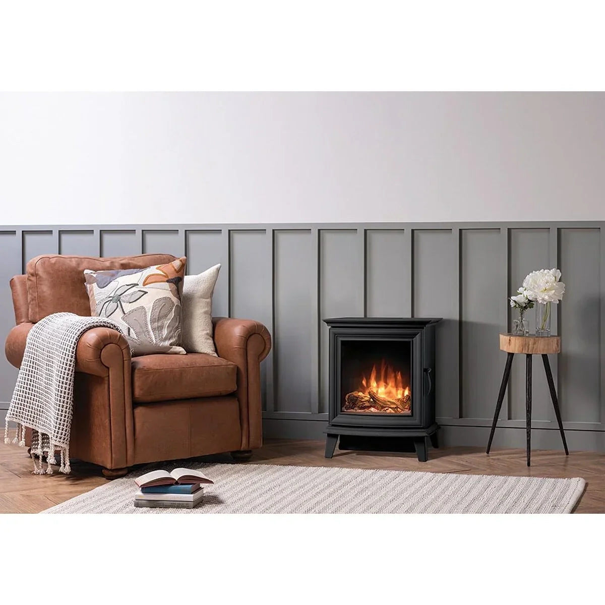 Brown leather armchair with cushions beside electric fireplace and wooden side table