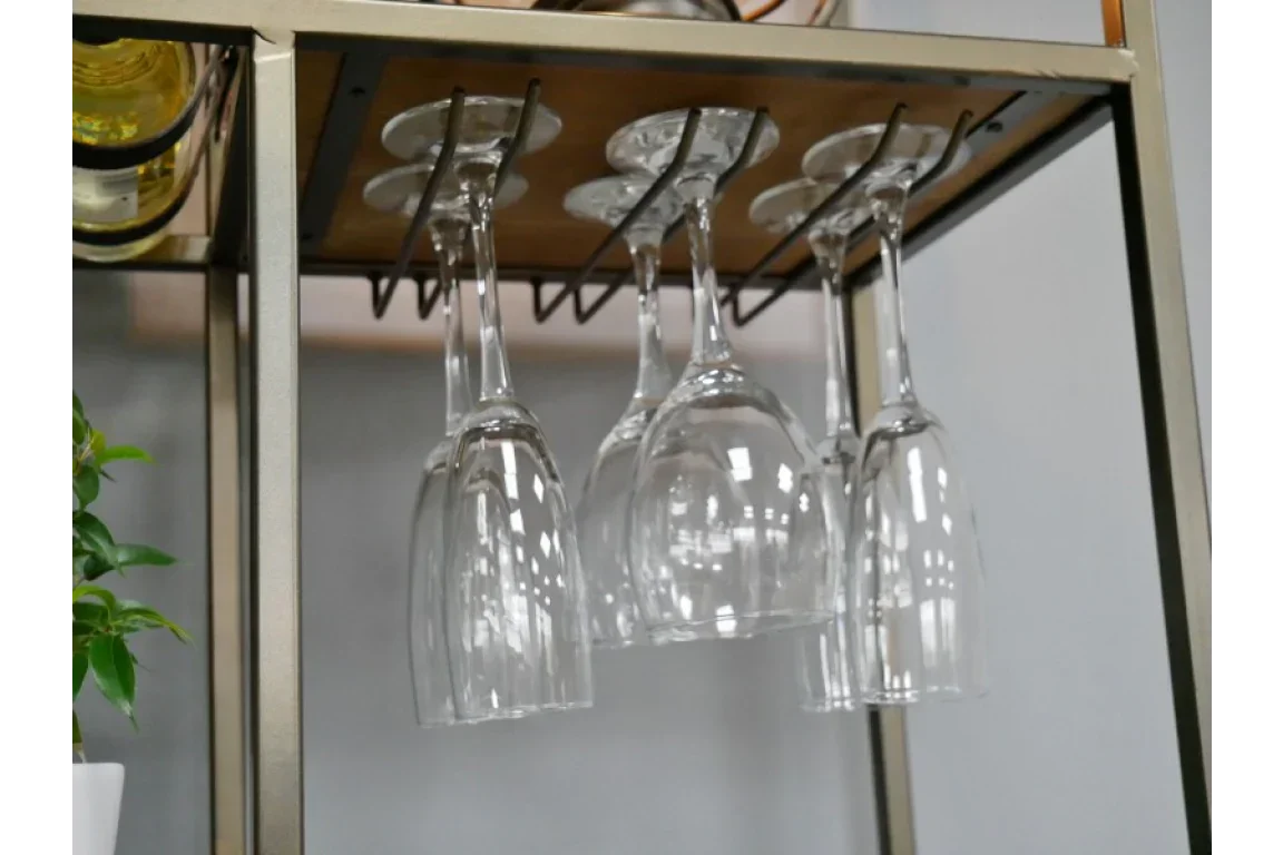 Wine glasses hanging upside down on metal rack under wooden shelf furniture unit