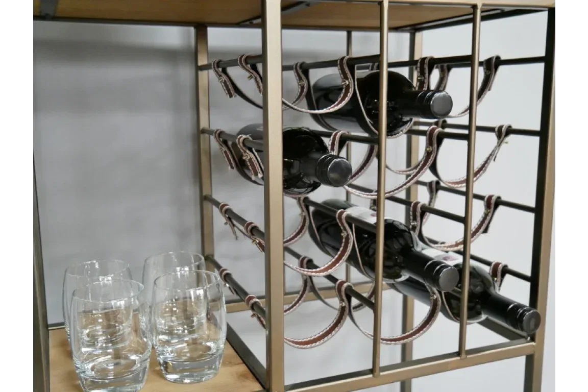 Metal wine rack with three wine bottles and four clear glasses on wooden shelf