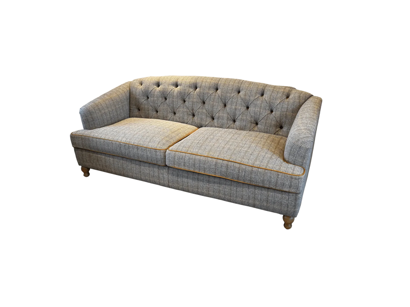 Grey fabric sofa with button-tufted back, wooden legs, and contrasting trim detail