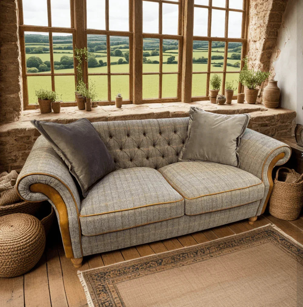 Grey fabric sofa with button-tufted back, yellow trim and two cushions in rustic room