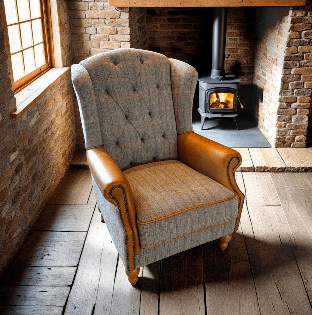 Wingback armchair with grey fabric and tan leather arms by a wood-burning stove