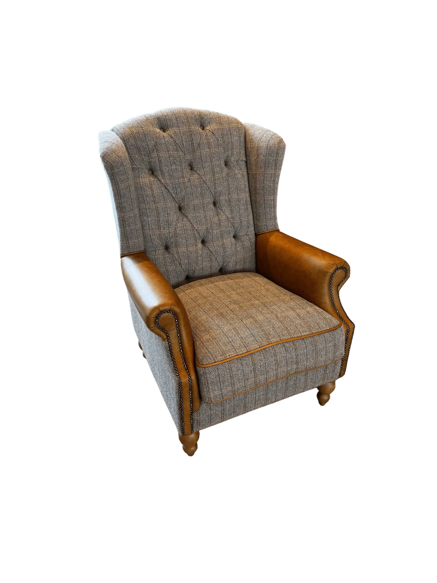 Grey fabric armchair with button-tufted back and tan leather rolled arms