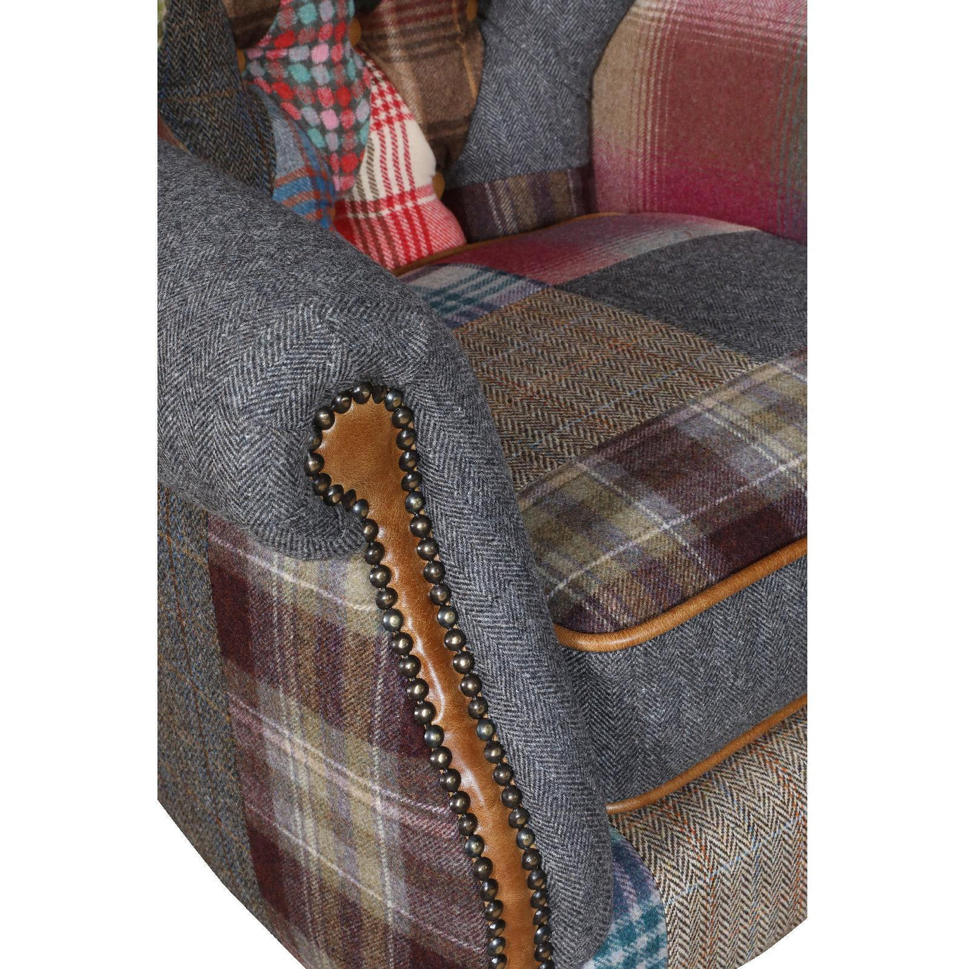 Patchwork armchair with multicolored fabric, studded brown trim, and tweed upholstery detail