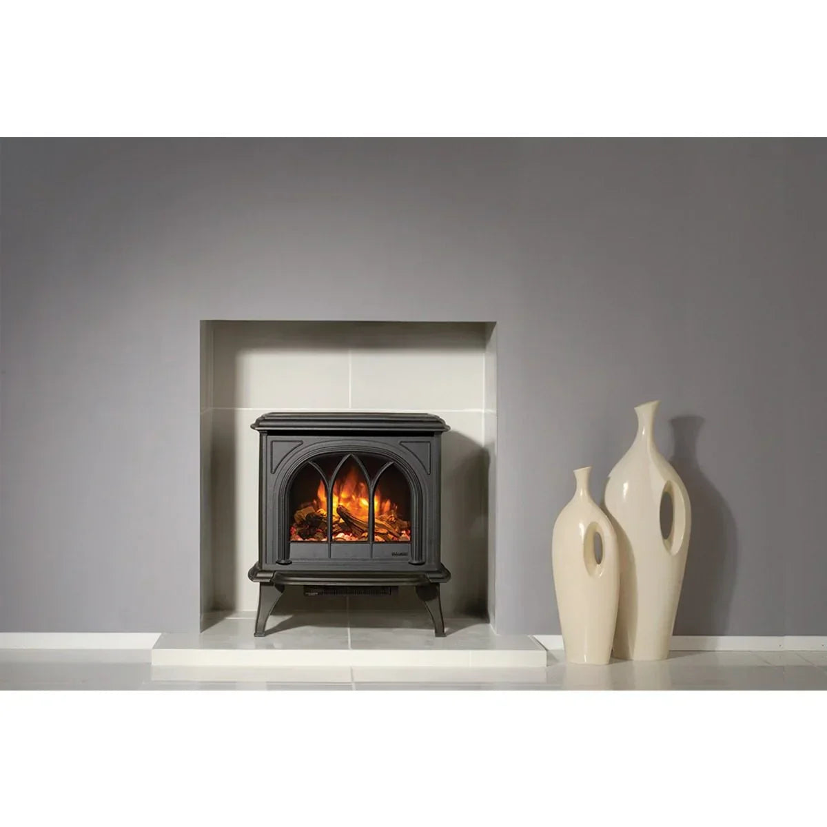 Black electric stove fireplace with flame effect beside two cream ceramic vases on tiled floor