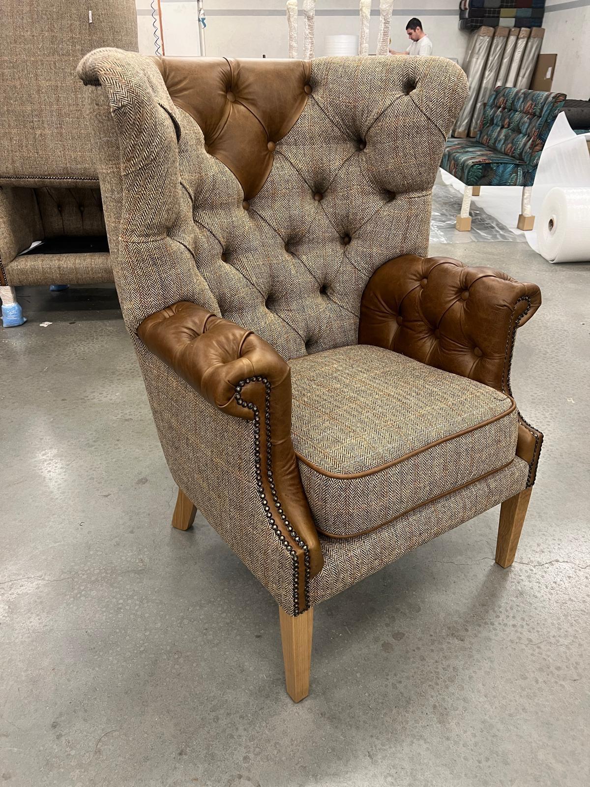 Tufted high back armchair with brown leather trim and herringbone fabric upholstery