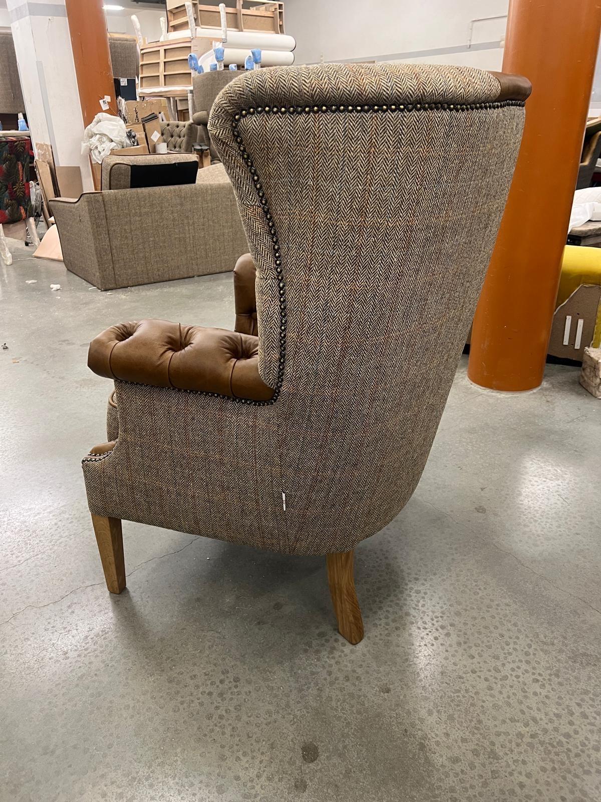 Herringbone fabric armchair with brown leather trim and buttoned seat, rear side view