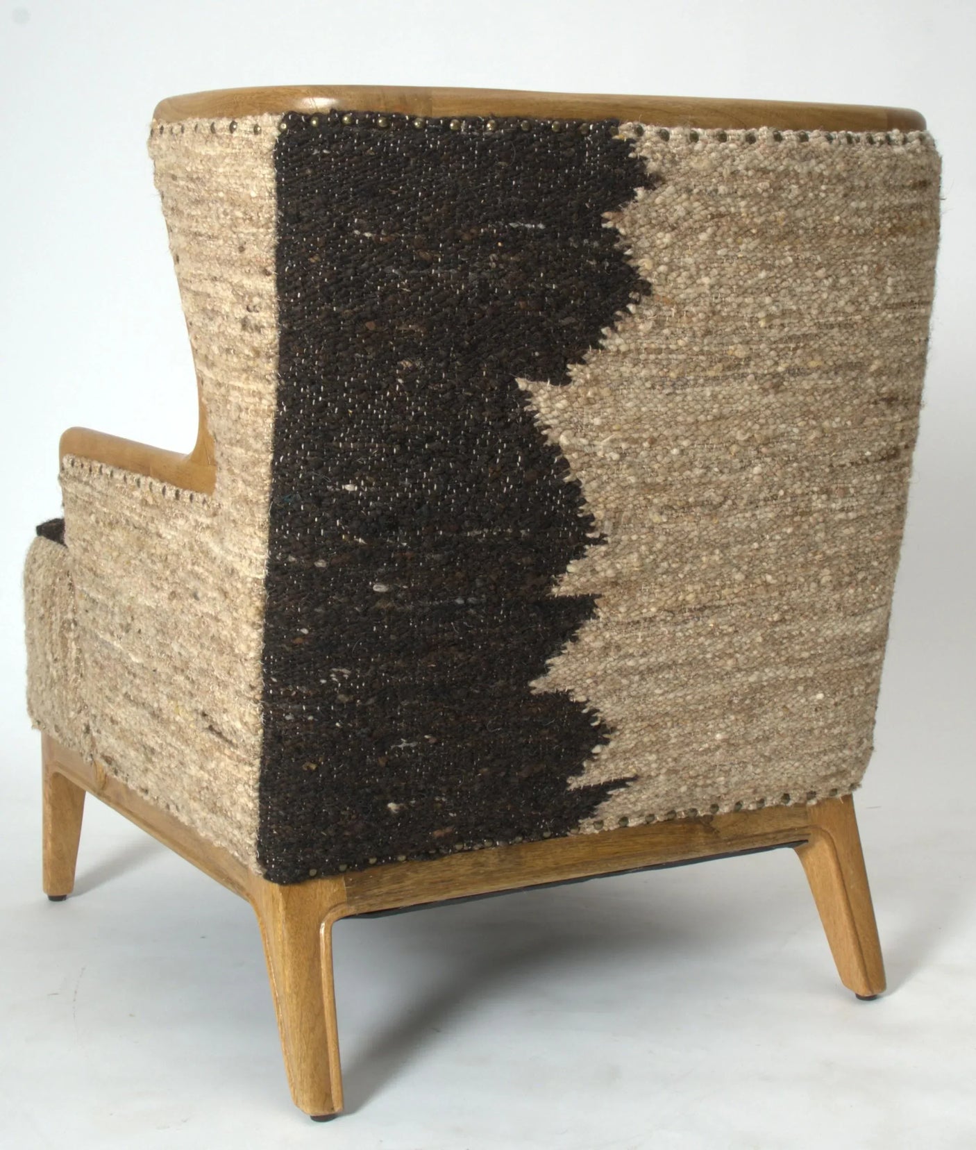 Back view of accent chair with woven beige and dark brown upholstery, wooden legs