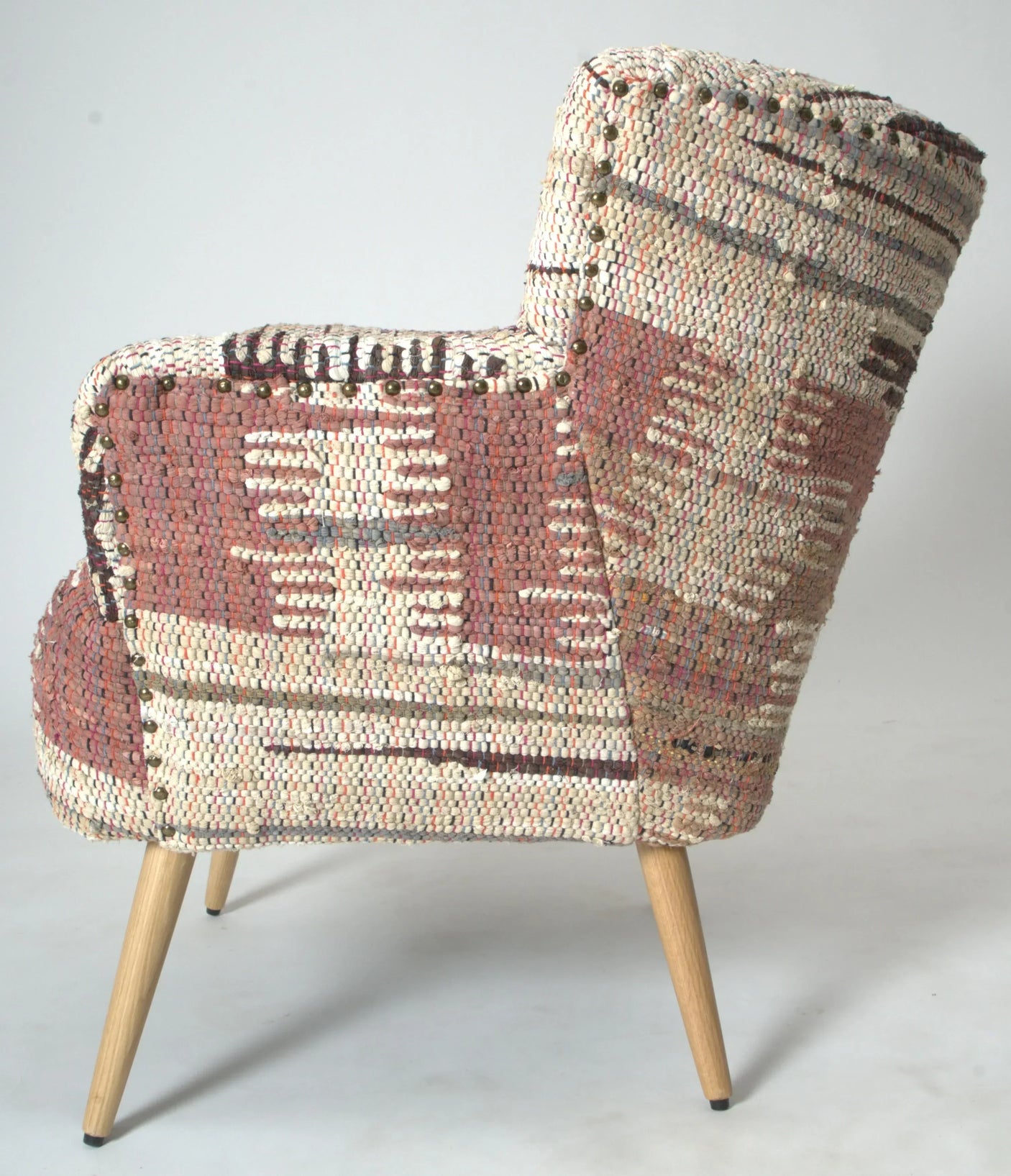 Patterned armchair with mid-century wooden legs and textured fabric upholstery