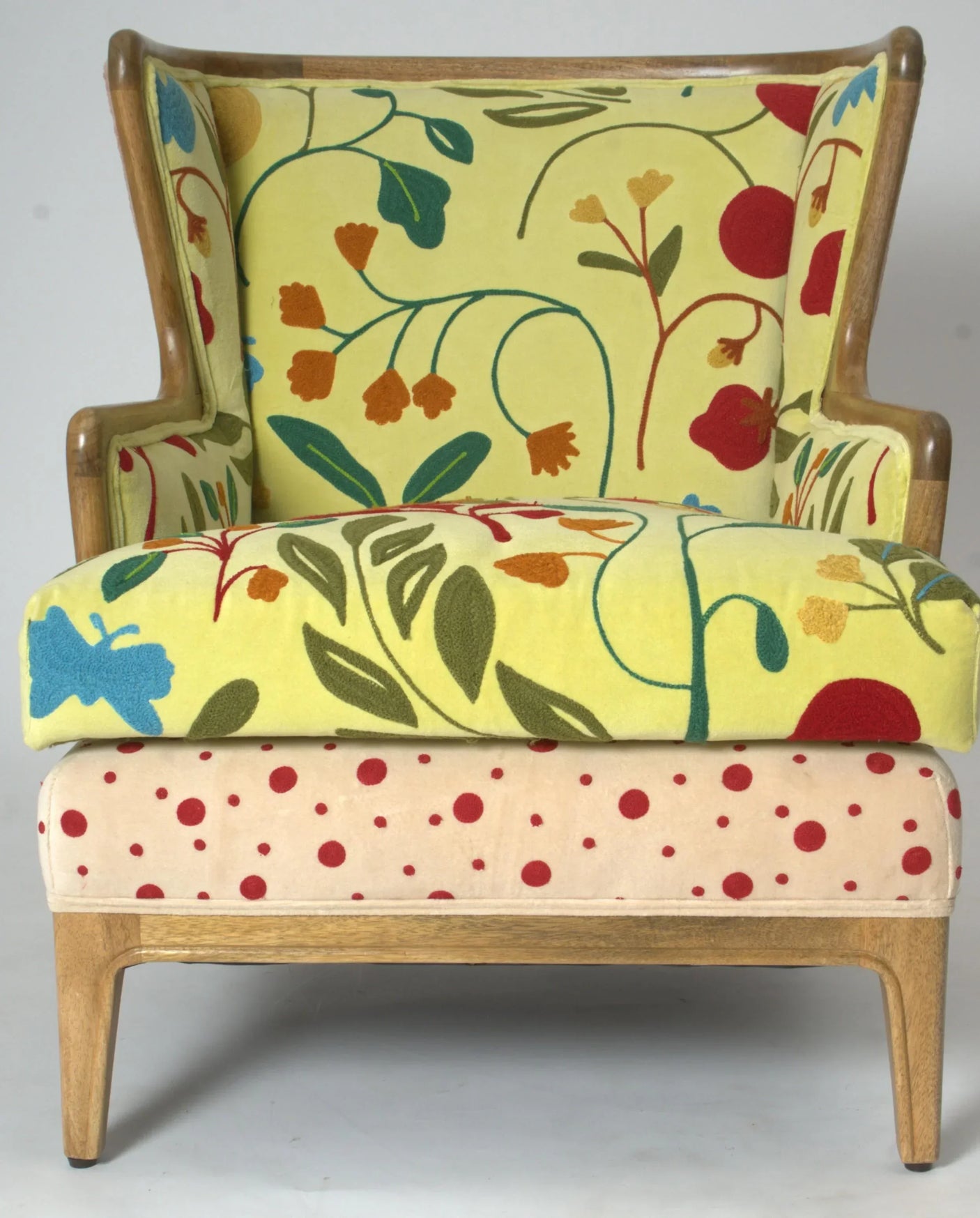 Upholstered armchair with yellow floral pattern and red polka dot seat on wooden legs