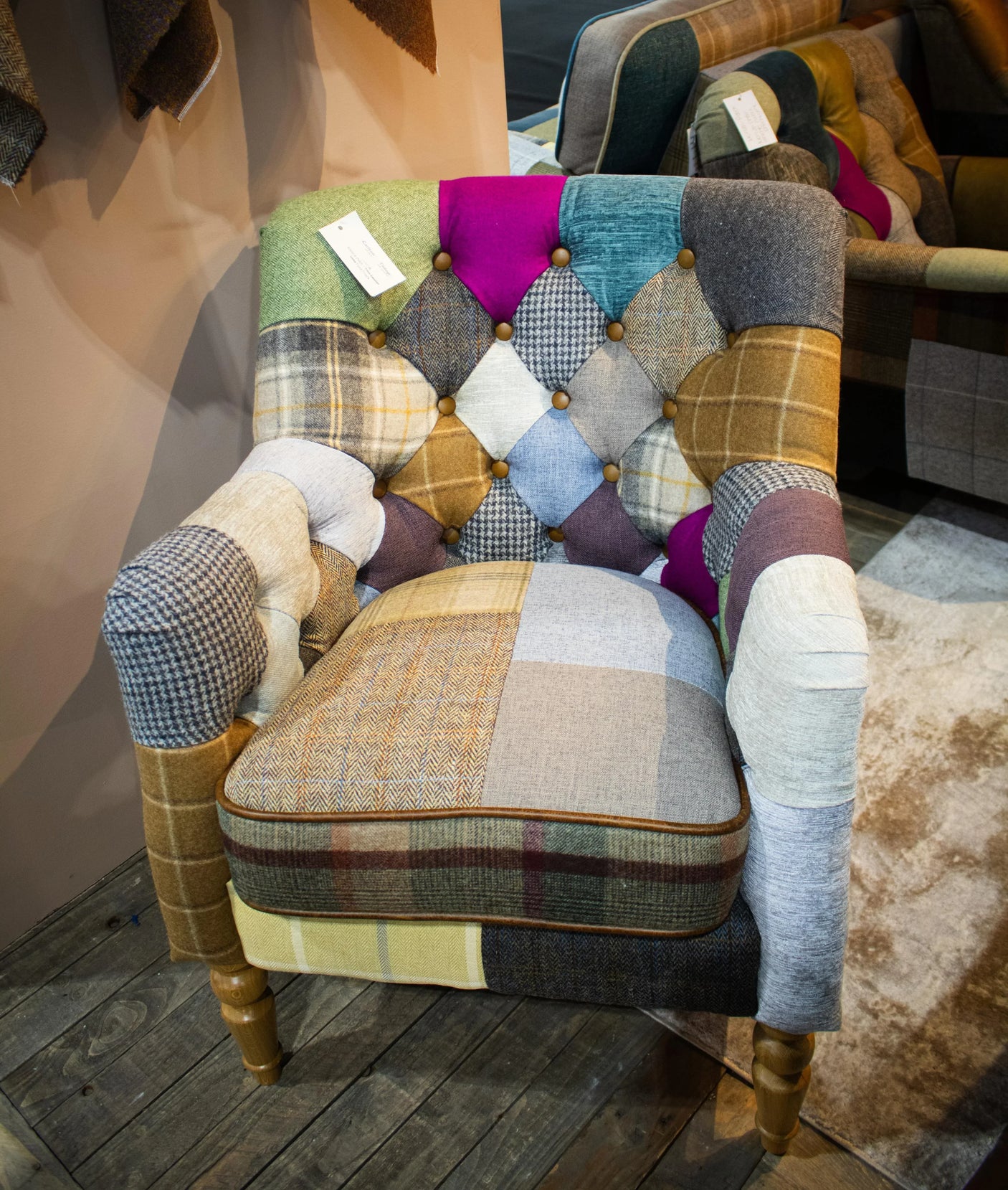 Patchwork armchair with multicolored fabric panels and button-tufted backrest on wooden legs