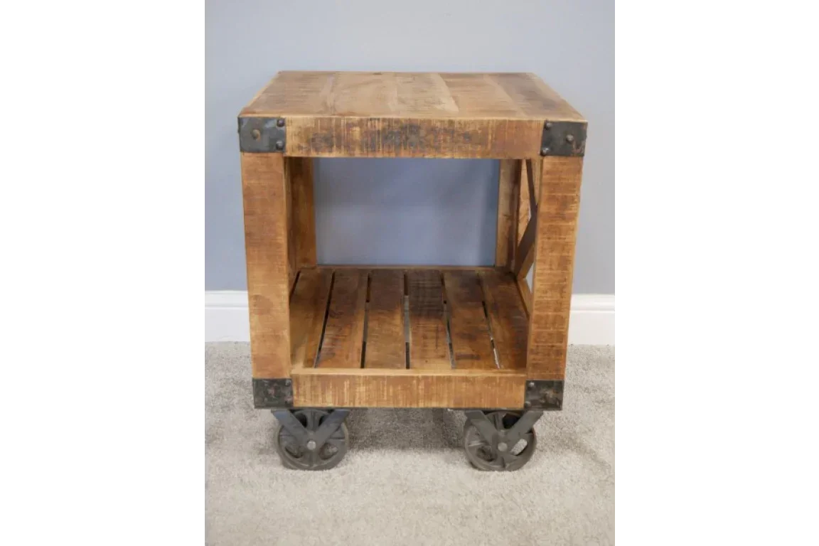 Industrial style wooden side table with shelf and metal caster wheels on carpet