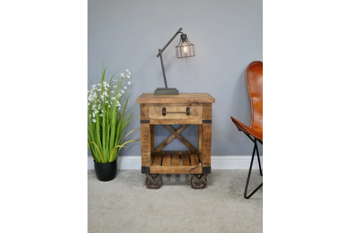 Rustic wood side table with metal wheels, drawer and open shelf in living room setting