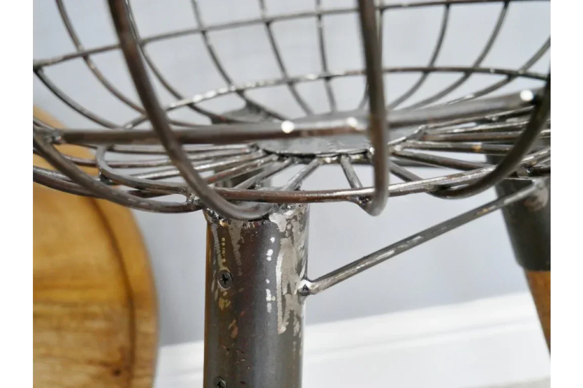 Close up of metal wire bar stool seat and leg with distressed finish