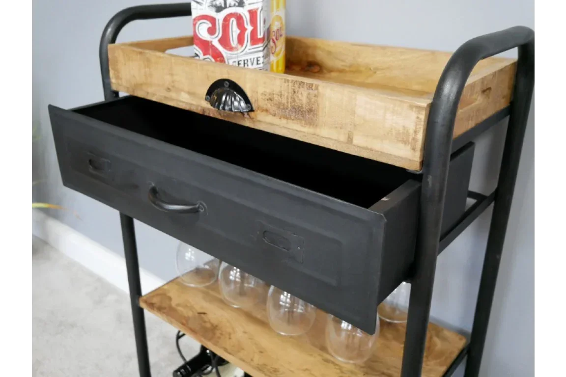 Industrial bar cart with black metal drawer, wooden shelves, and glasses stored underneath