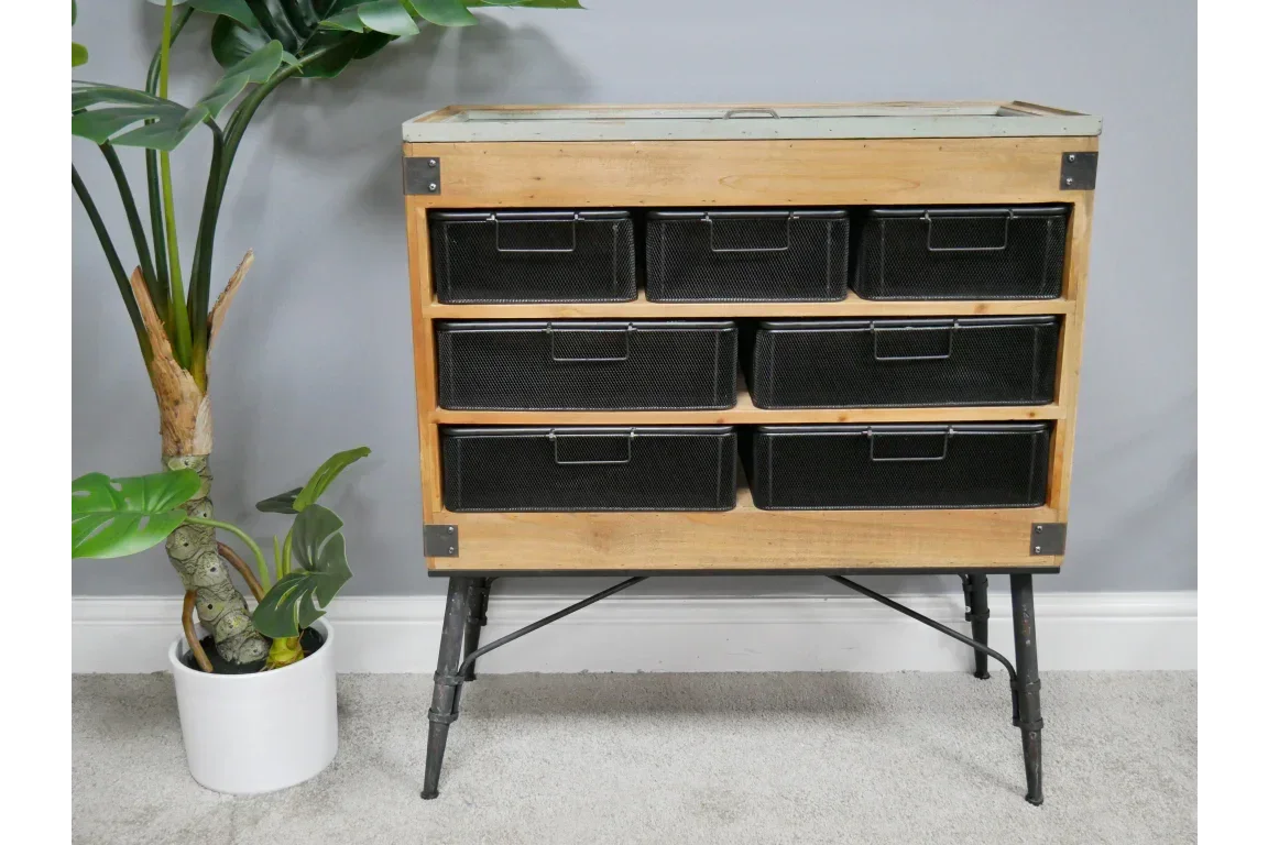 Industrial storage unit with six black mesh drawers and metal legs against grey wall