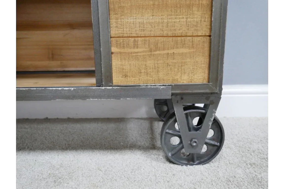 Industrial furniture wheel detail with metal frame and natural wood cabinet finish