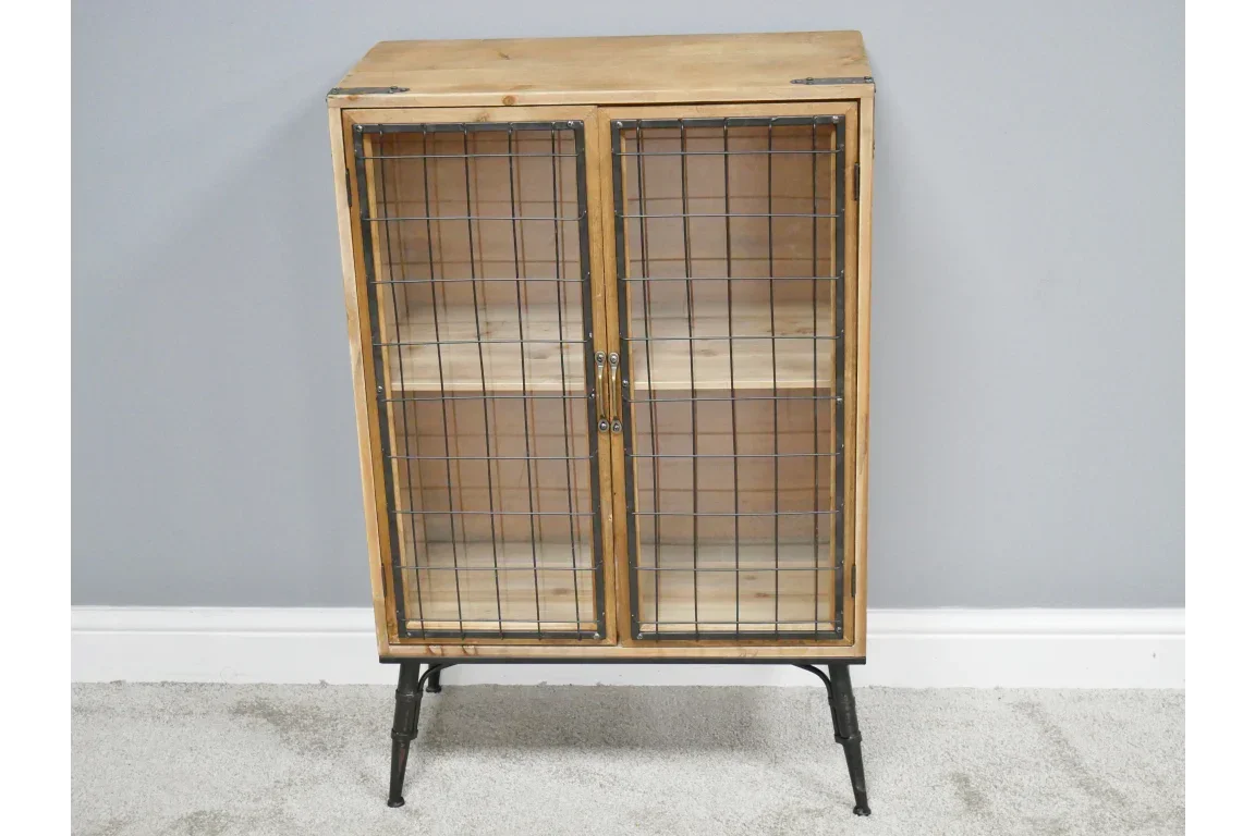 Industrial wood storage cabinet with wire mesh doors and black metal legs against grey wall