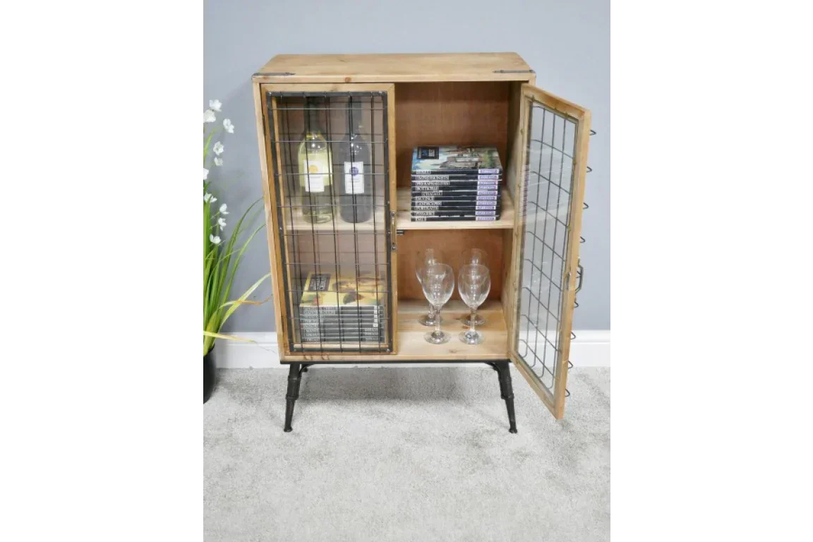 Industrial wood and metal storage cabinet with mesh doors, wine bottles, books, and glassware inside