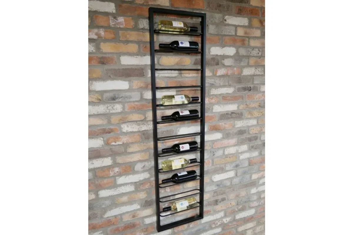 Wall mounted metal wine rack holding assorted bottles against exposed brick background