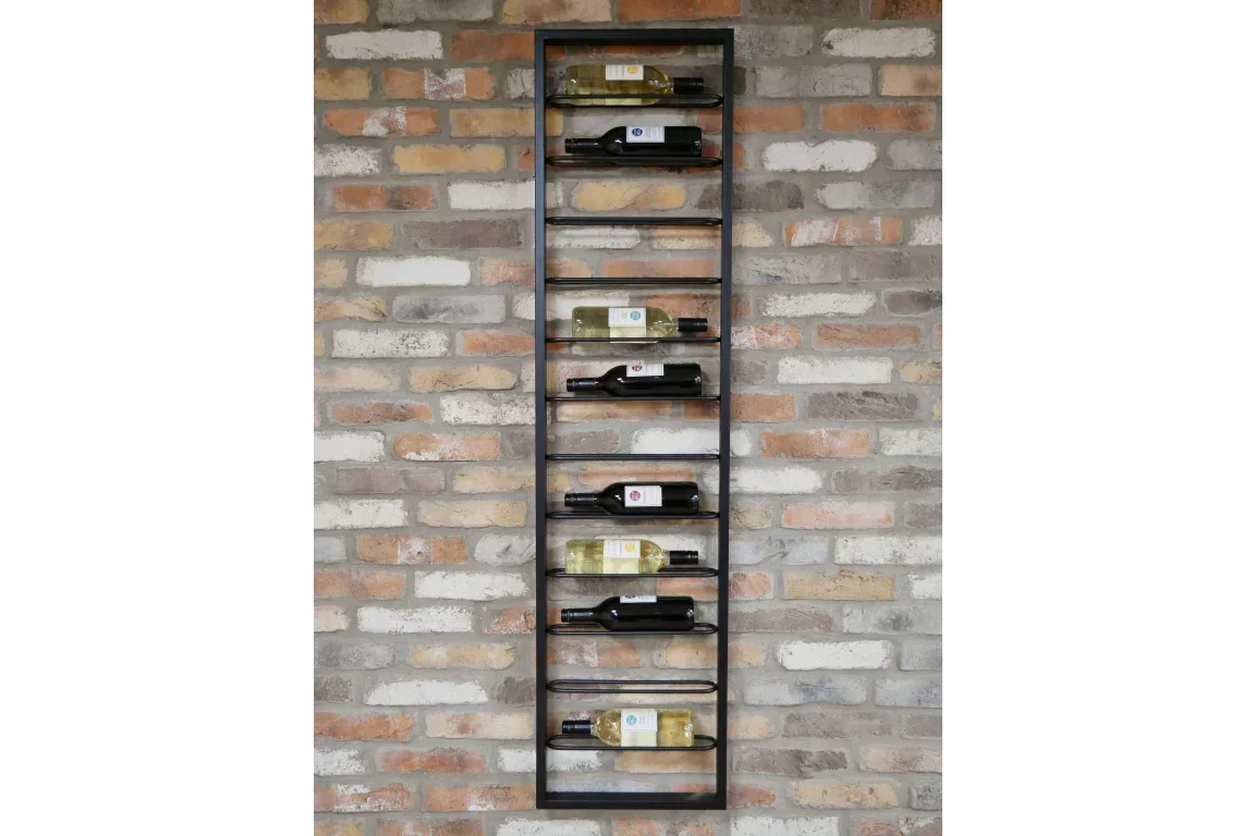 Black metal wall mounted wine rack holding bottles against exposed brick wall