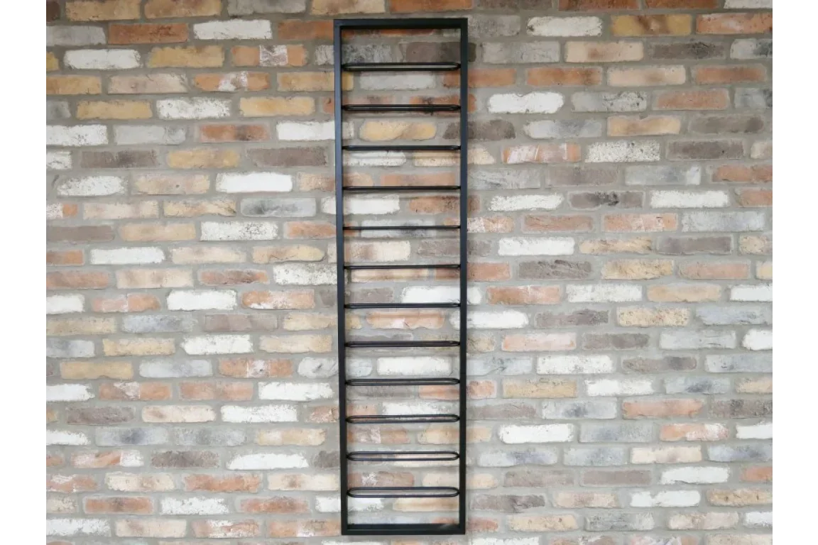 Black metal wall mounted wine rack on exposed brick wall