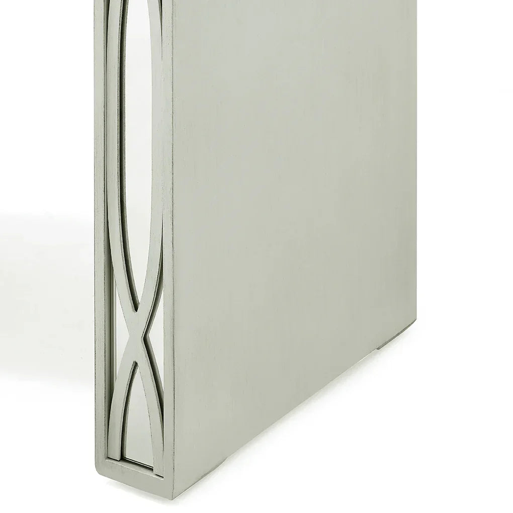 Closeup of silver table leg with decorative cut-out detail on side panel