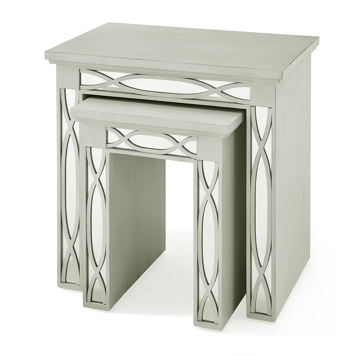 Two sage green nesting tables with mirrored X-frame legs, angled view