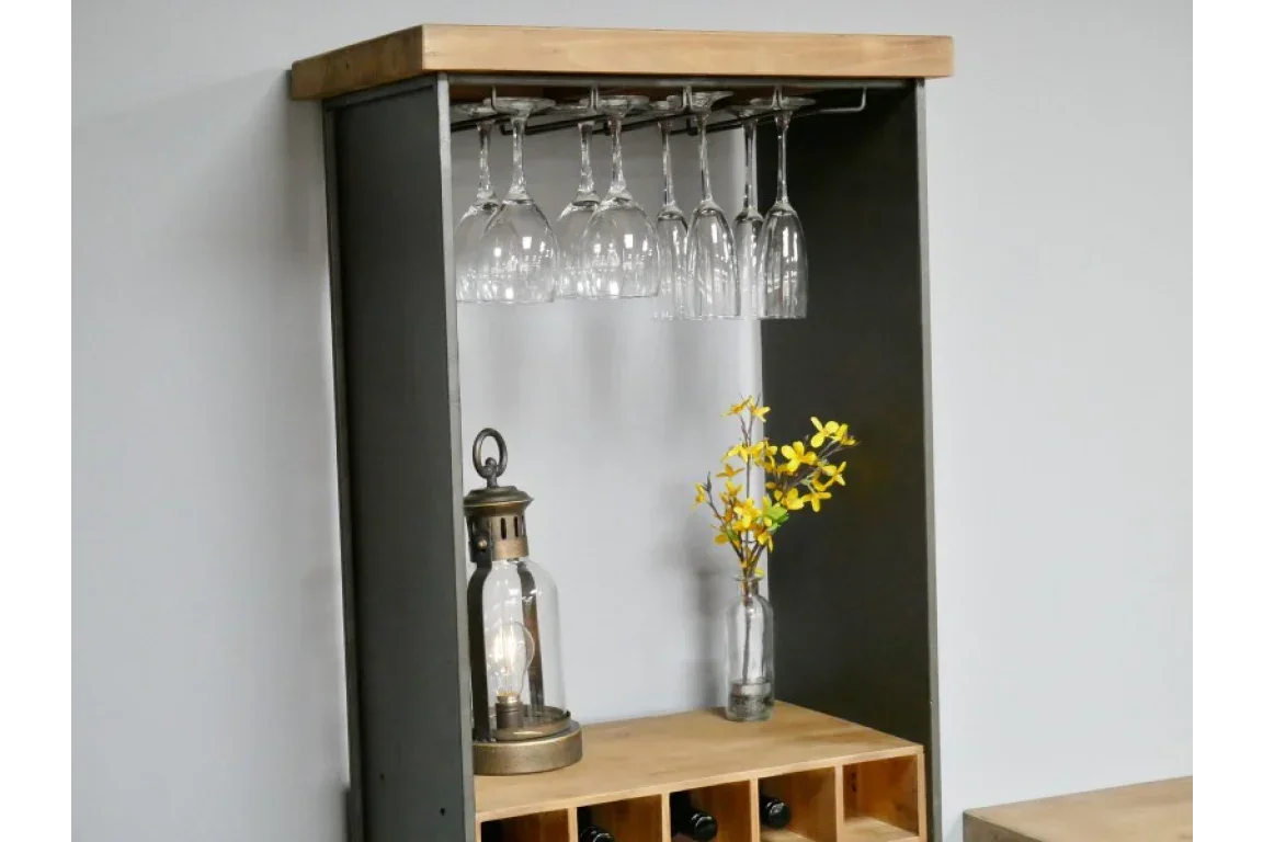 Wood and metal wine rack with hanging glasses, a lantern, and yellow flowers in a vase