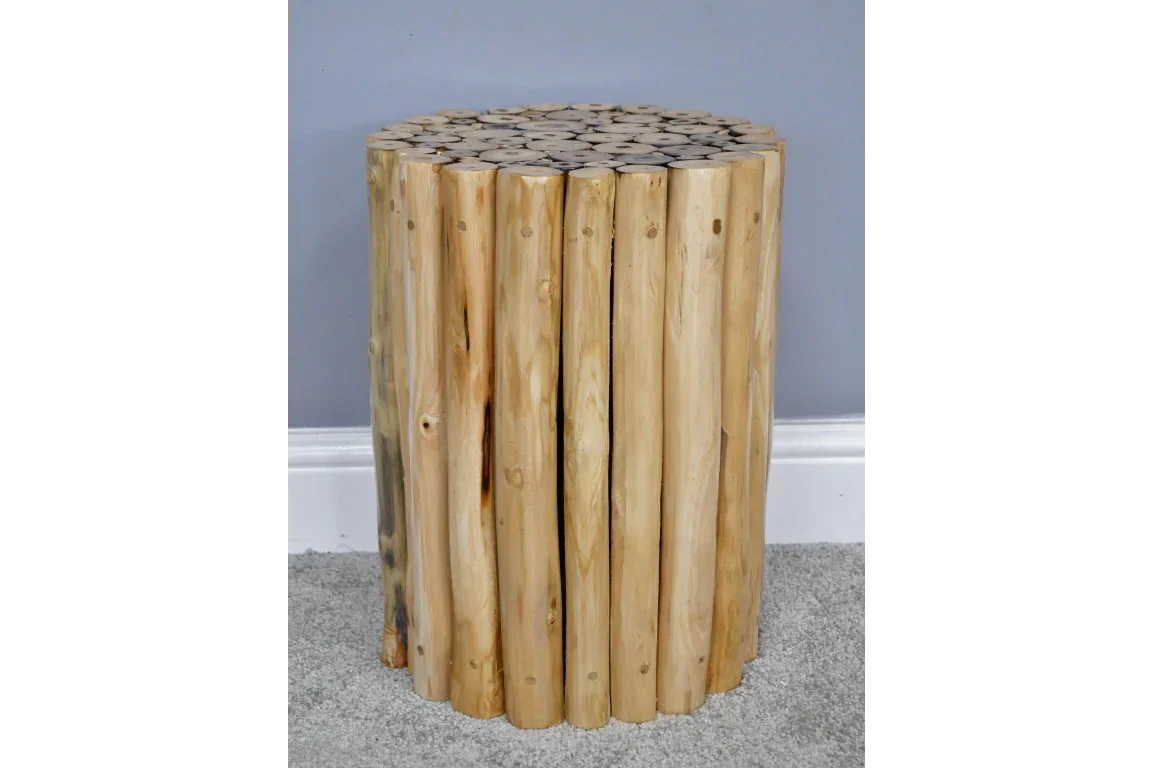 Round wooden side table made from natural log pieces on grey carpet