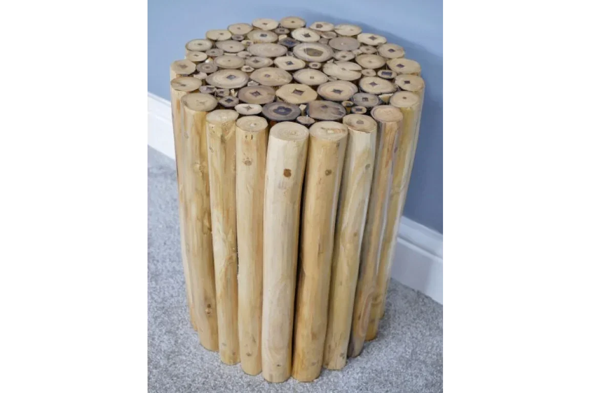 Round wooden side table with natural log design on grey carpet and blue wall background