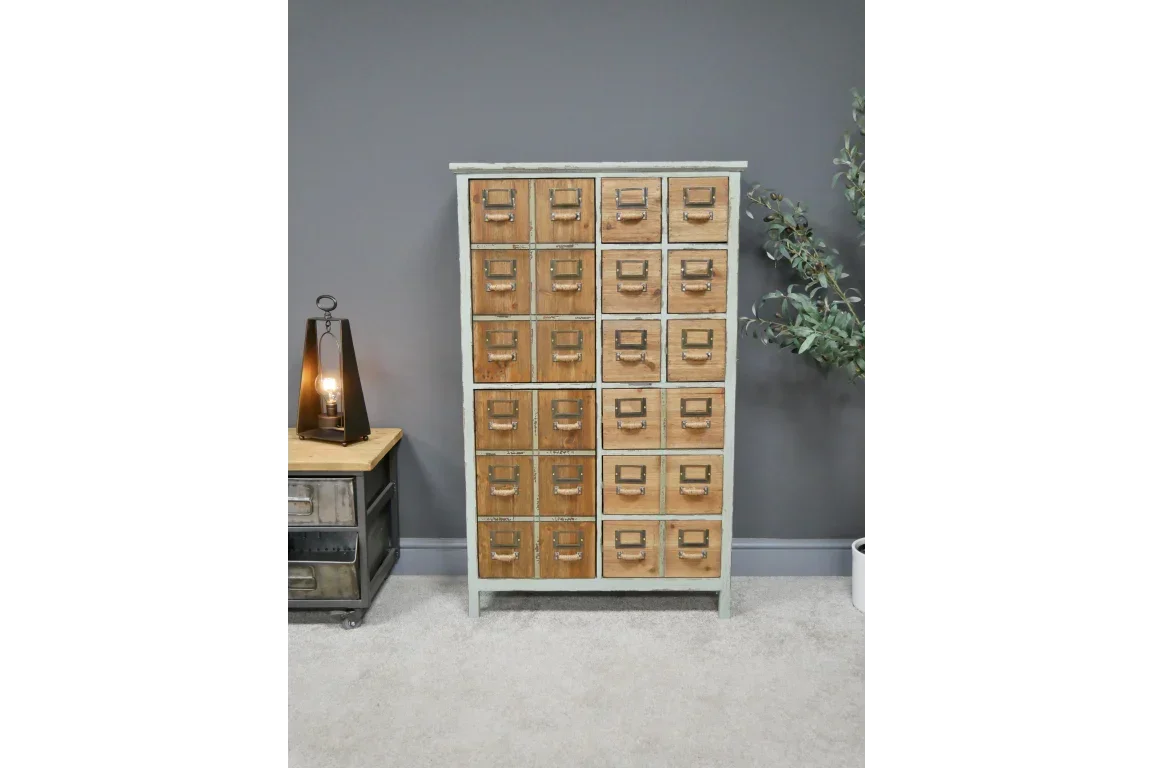 Wooden apothecary cabinet with 24 drawers and metal handles against grey wall