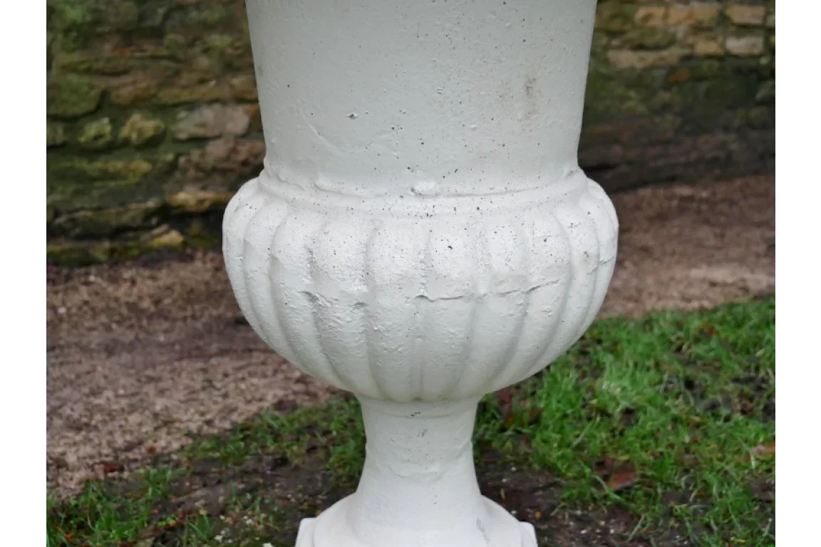 white stone garden planter with fluted detailing on outdoor grass and soil area