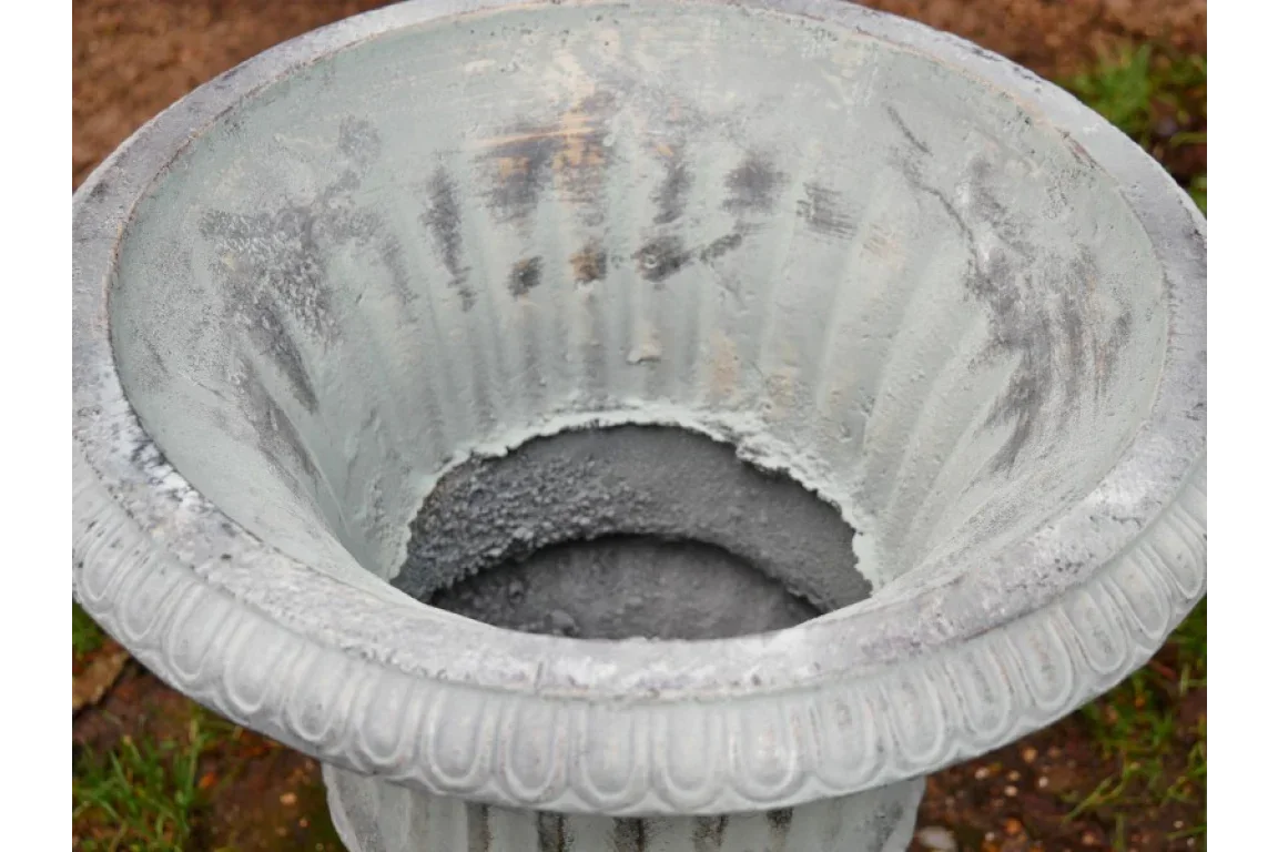 Weathered grey garden planter with fluted design and wide opening, outdoor view