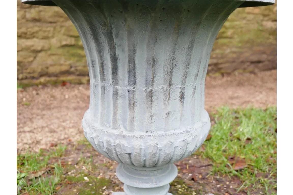 Close view of grey stone garden planter with textured vertical ridges outdoors
