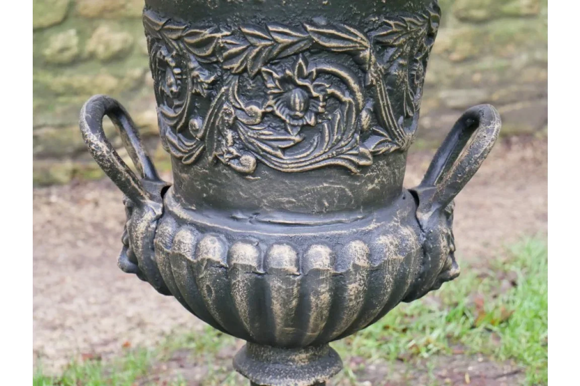 Cast iron garden planter with decorative floral detailing and twin handles