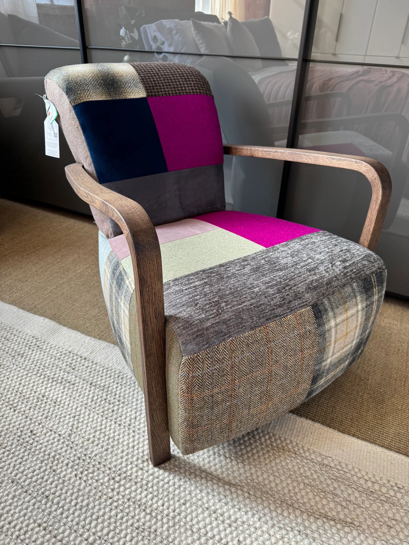 Patchwork accent chair with wooden arms on textured rug in living room setting