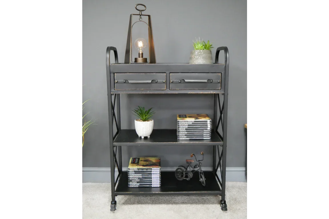 Black industrial storage shelf with two drawers, books, plants, and lamp on top