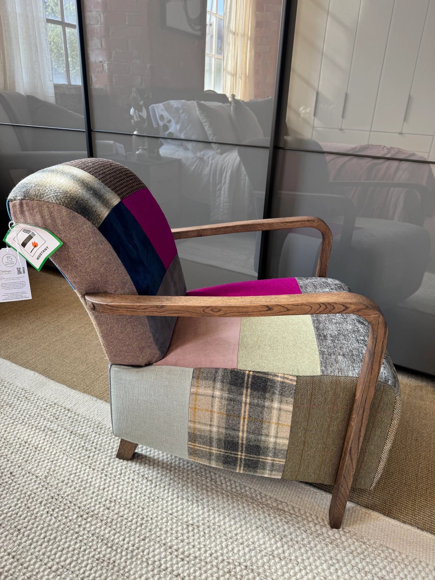 Patchwork accent armchair with wooden frame and multicolour fabric panels on carpeted floor