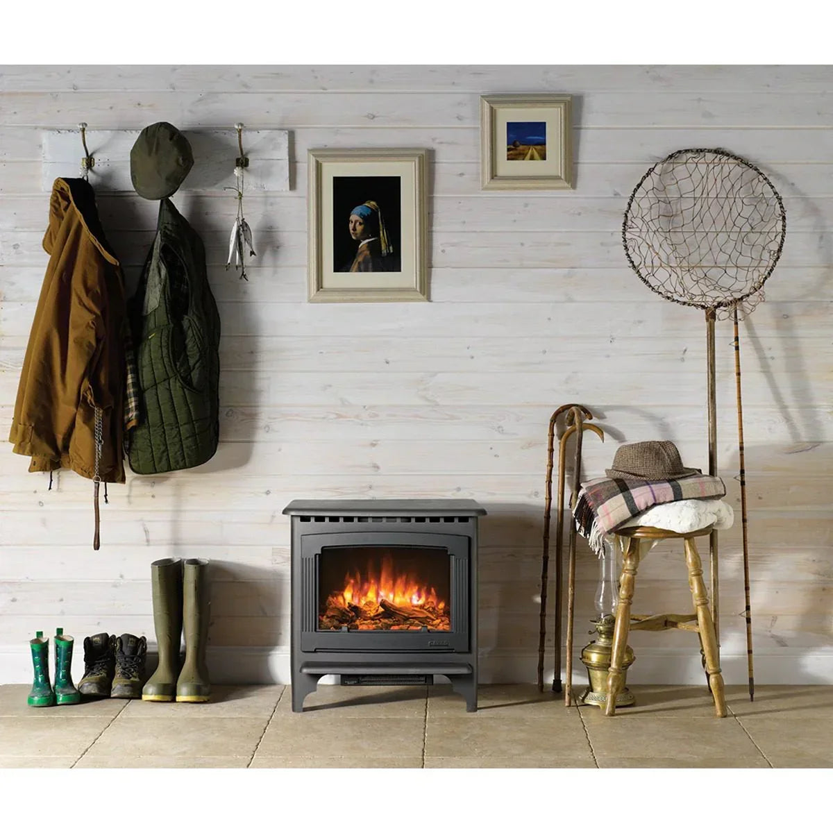 Black electric fireplace stove in rustic hallway with boots, coats, and fishing net