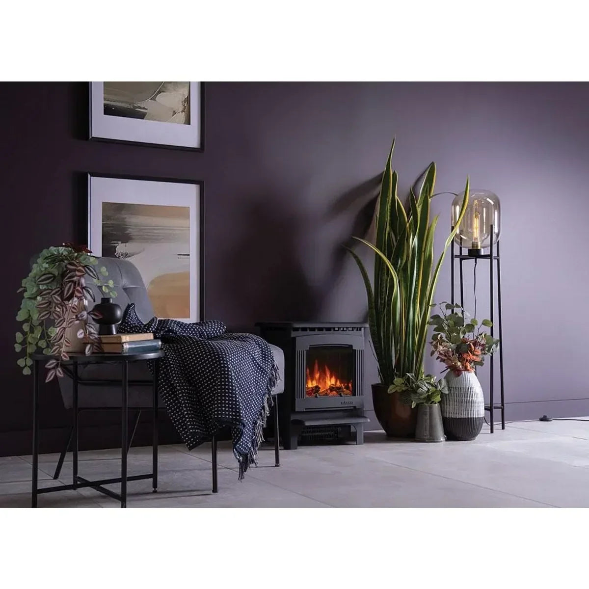 Living room with electric fire stove, potted plants, accent chair and side table