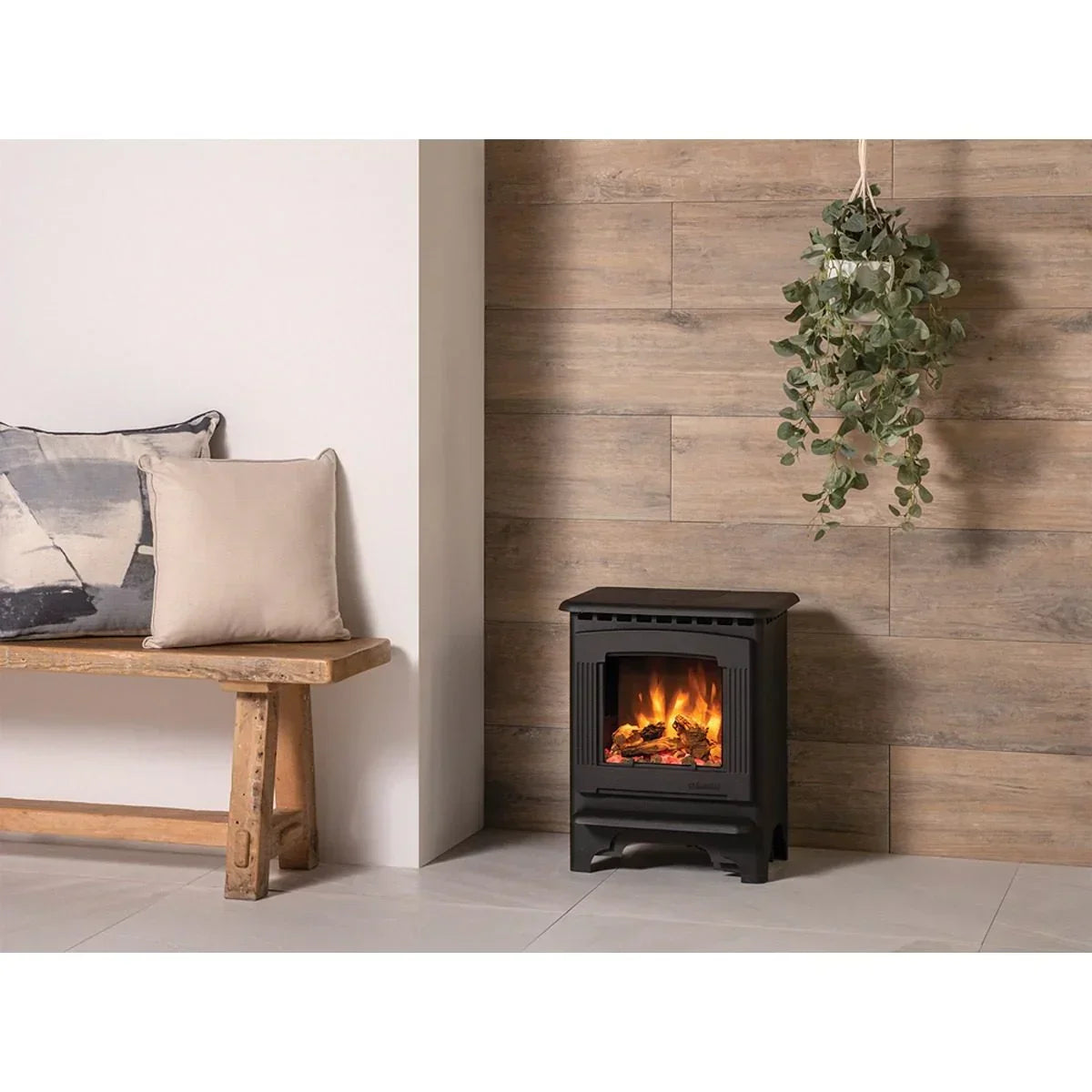 Black electric stove heater beside wooden bench with cushions in modern living room