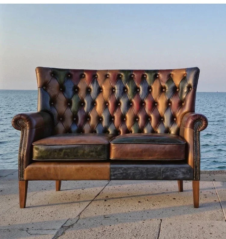 Two seater leather Chesterfield sofa with tufted backrest on seafront terrace